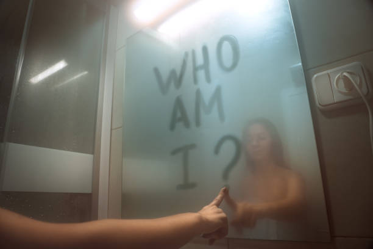 Picture3 Frosted glass with the caption 'WHO AM I?'; a person is visible behind the glass, while a hand presses on the outside.